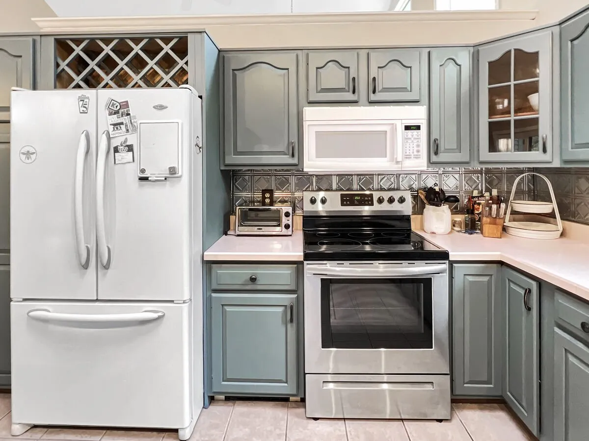 Featuring sleek stainless steel appliances including a refrigerator, stove, and microwave, this image focuses on the essential elements of a modern kitchen. The cabinetry and backsplash add contemporary flair while emphasizing the kitchen's practicality and inviting atmosphere.